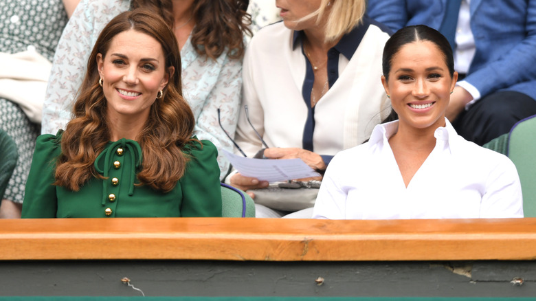Princess Catherine and Meghan Markle sitting together at Wimbledon