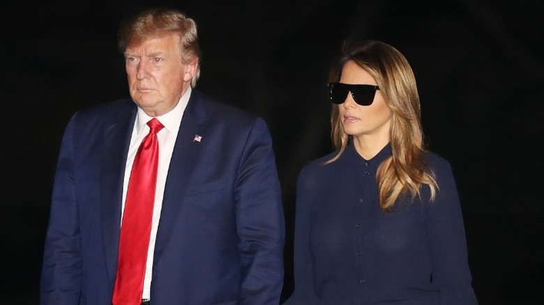 Donald Trump and Melania Trump walk to the White House at night in Washington, DC (2019)