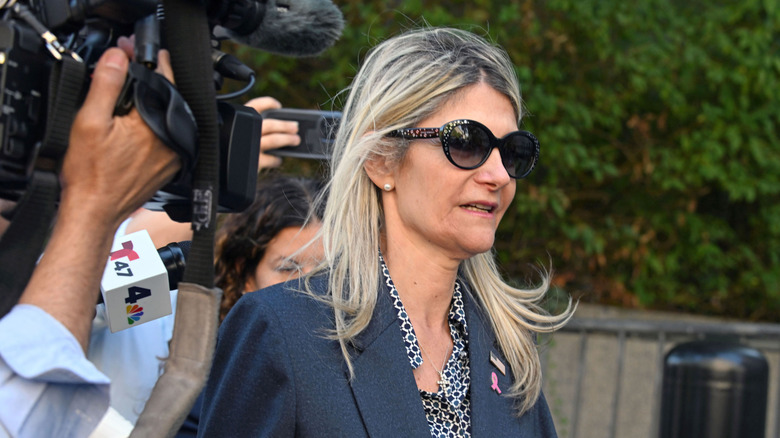 Nadine Menendez, surrounded by cameras and microphones, as she walks.