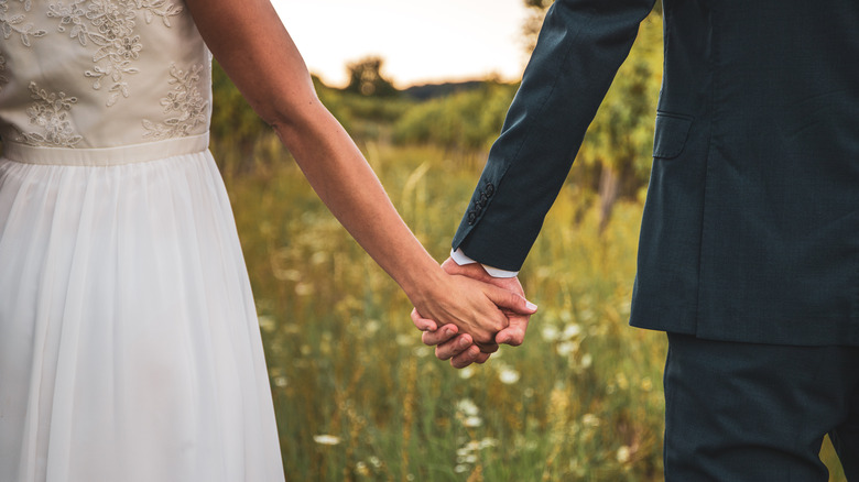 bride and groom hold hands