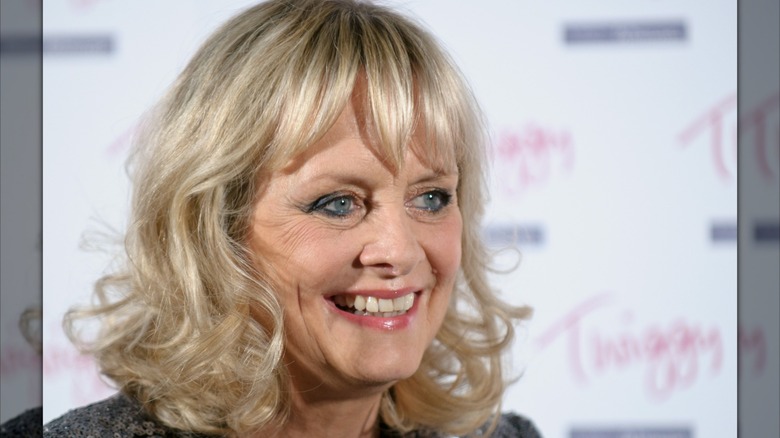 An older Twiggy smiling brightly