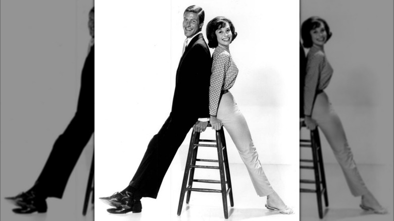 Mary Tyler Moore poses next to Dick Van Dyke in pants and a gingham shirt