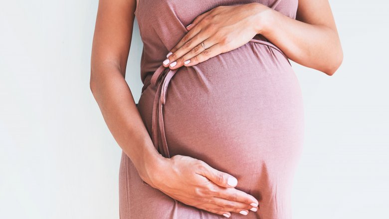 pregnant woman with hands over belly