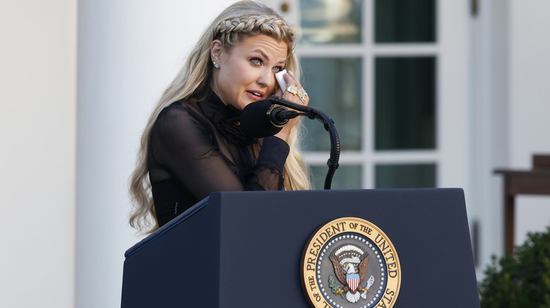 Erika Kirk delivering a speech while wiping away tears