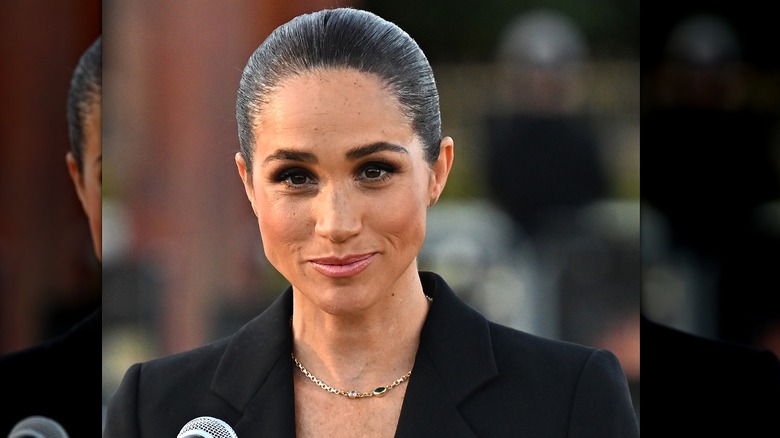 Meghan Markle in dark suit hair pulled back