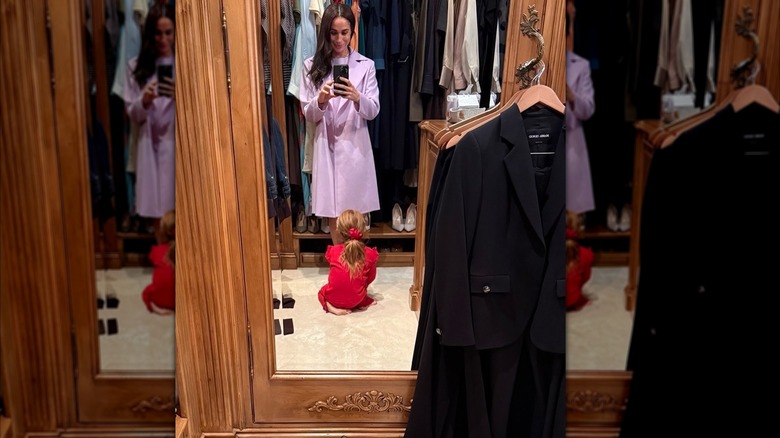 Meghan Markle in mirror with purple dress and Lilibet