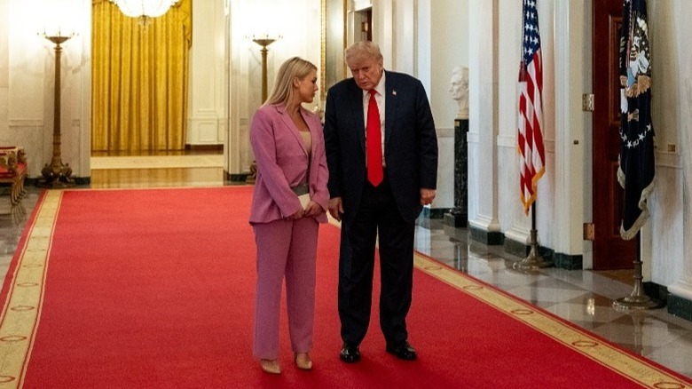 Karoline Leavitt and Donald Trump whisper to each other inside the White House in Washington, DC (2025)