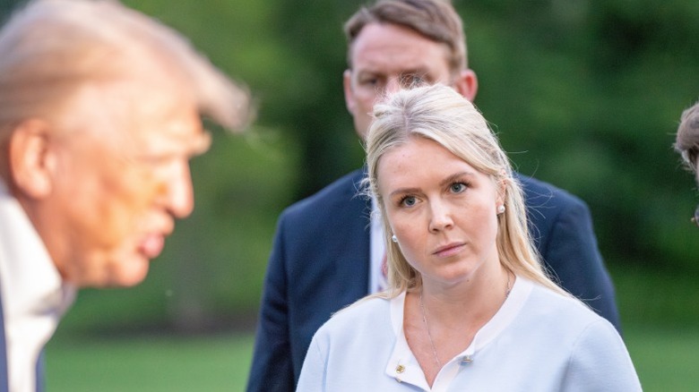 Karoline Leavitt stares at Donald Trump as he speaks to the press in Washington, DC (2025)