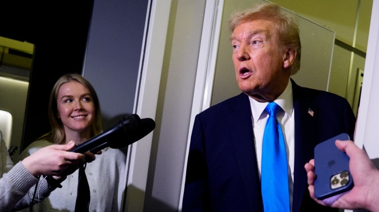 Karoline Leavitt smiles as Donald Trump answers questions at Al-Udeid Air Base in Abu Nakhlah, Qatar (2025)