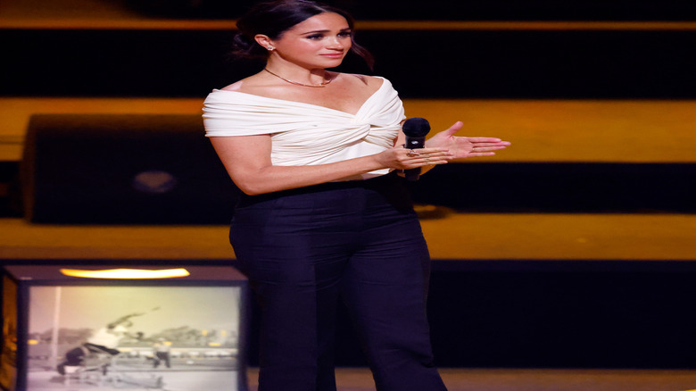Meghan Markle on stage at the 2020 Invictus Games in a white blouse