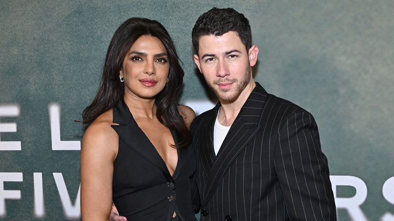 Priyanka Chopra and Nick Jonas embracing on a 2025 red carpet