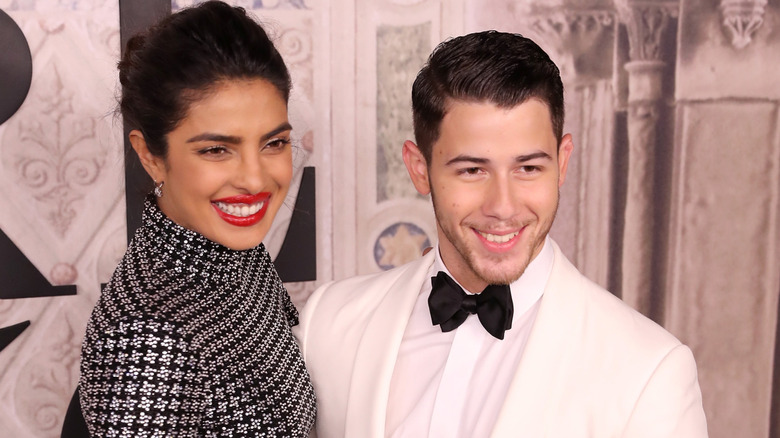 Priyanka Chopra and Nick Jonas smiling wide on a 2018 red carpet