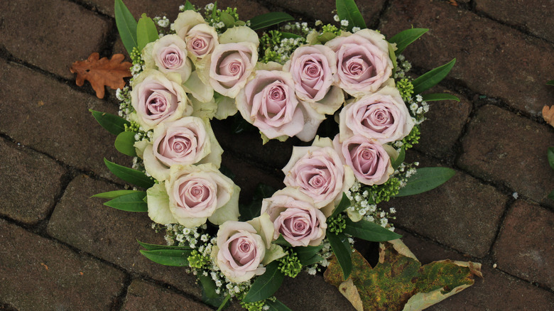 a heart shaped wreath adorned with purple roses