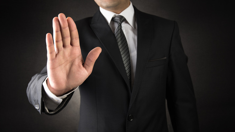 a man holds up his hand a signal to stop