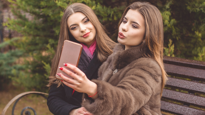 Two girls making duck faces while taking a selfie