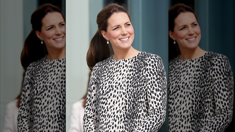 Kate Middleton smiles in a white-and-black patterned dress