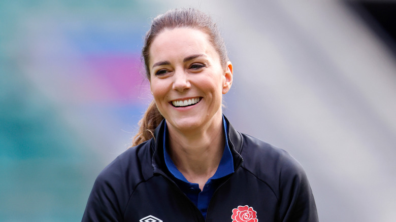 Kate Middleton smiles in a ponytail and blue jacket