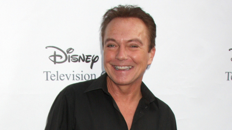 David Cassidy looking to the left in black outfit at a Disney event.