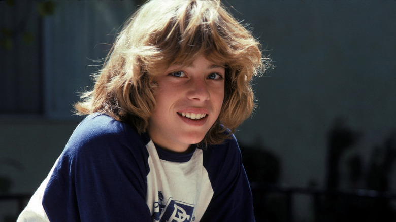 Leif Garrett in blue and white tee shirt with long hair