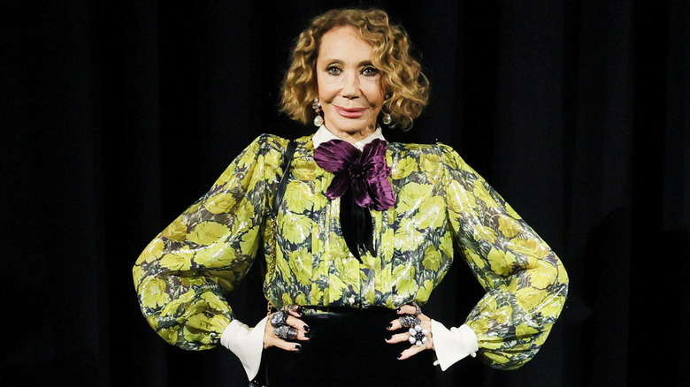 Marisa Berenson smiling with her hands on her hips