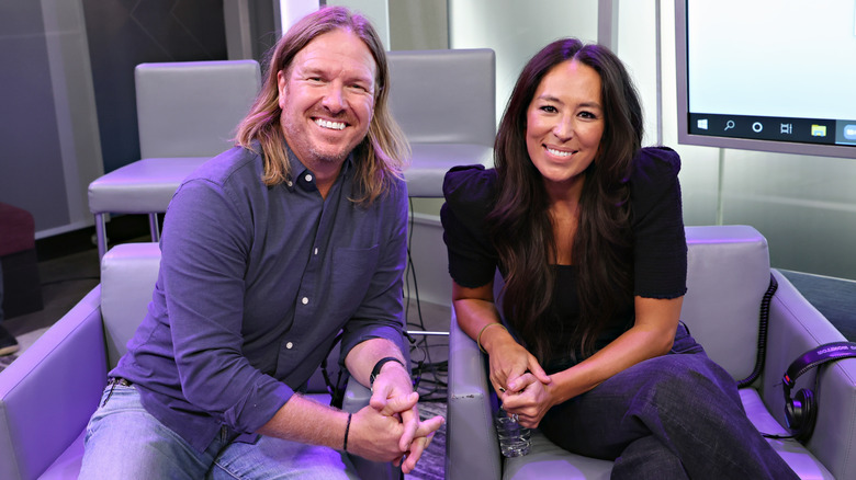 Chip and Joanna Gaines sitting on studio chairs 2021