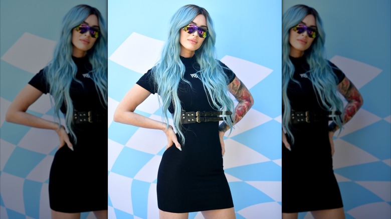 Megan Fox in a black dress with blue hair at an event