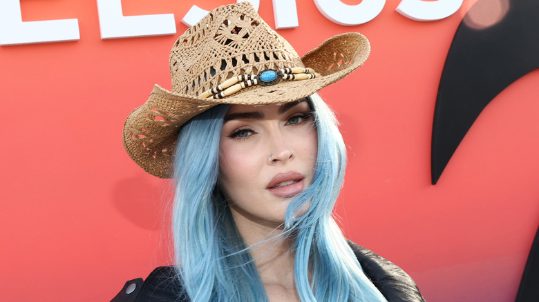 Megan Fox with blue hair and a cowboy hat