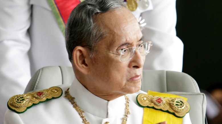King Bhumibol Adulyadej of Thailand leaving a hospital on his 82nd birthday