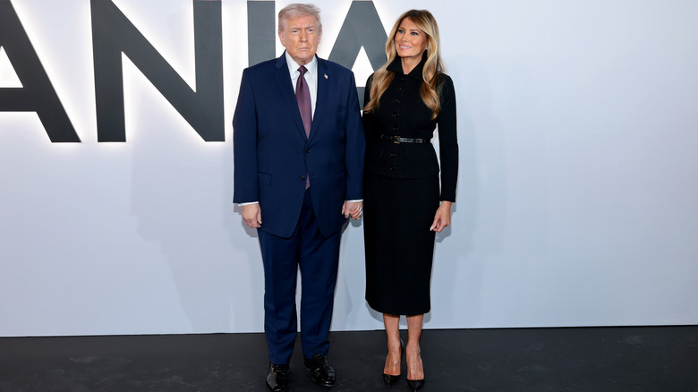 Melania Trump holding hands with a frowning Donald Trump at the premiere of her documentary.
