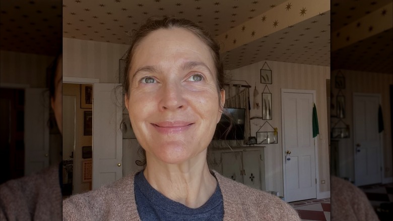 Closeup Drew Barrymore smiling with no makeup gray sweater