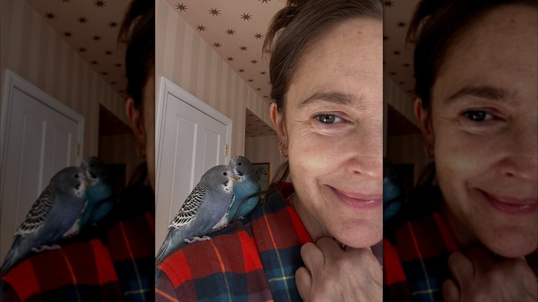 Drew Barrymore no makeup smiling with her birds on shoulder