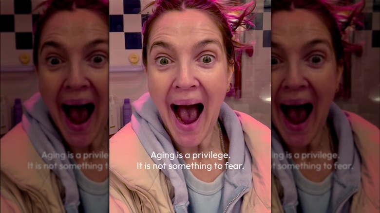 Drew Barrymore opening her eyes wide with her mouth open no makeup closeup, wearing sweats.