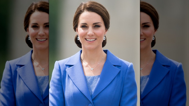 Kate Middleton smiling in a blue suit.