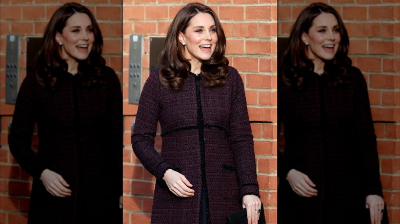Kate Middleton smiling in a plum jacket.