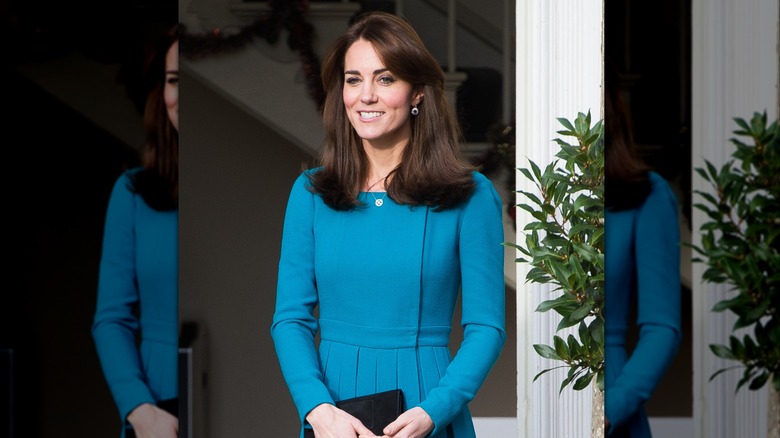 Kate Middleton smiling in a blue dress.