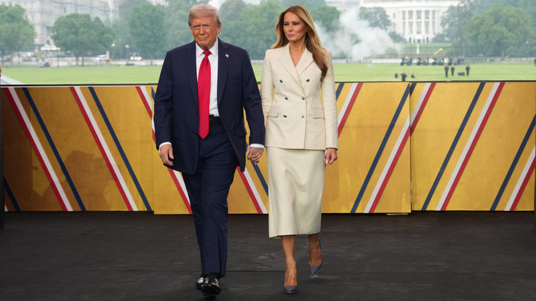 U.S. President Donald Trump and First Lady Melania Trump walk on stage during a celebration of the Army's 250th birthday on the National Mall on June 14, 2025 in Washington, DC (2025)