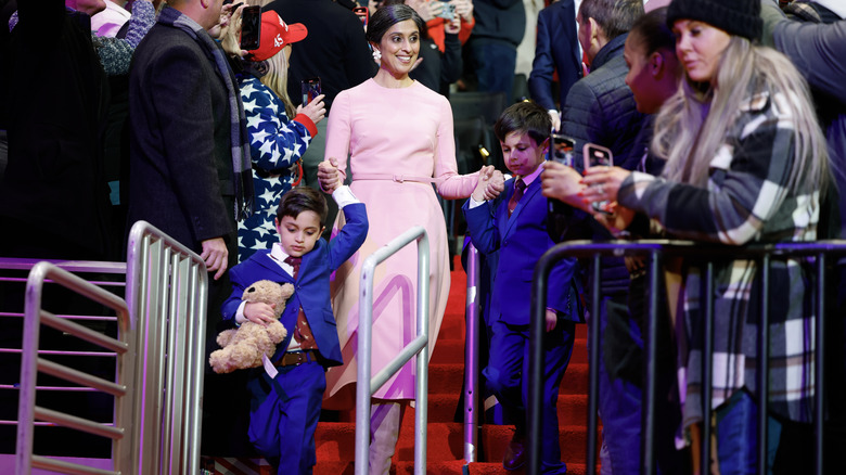 Usha Vance holding her children's hands at an indoor inauguration event