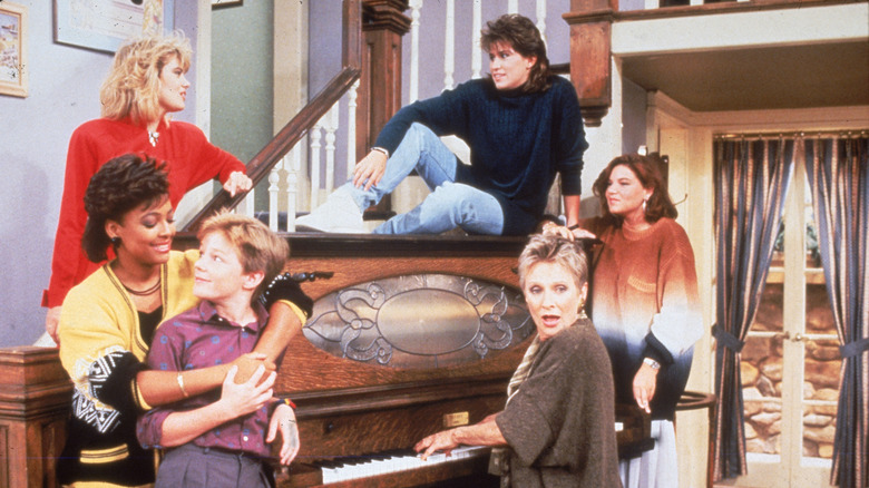 The cast of The Facts of Life around a piano