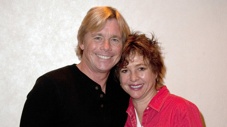 Christopher Atkins & Kristy McNichol leaning in close and smiling together