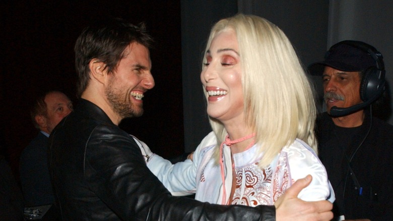 Tom Cruise and Cher smiling and holding each other's shoulders