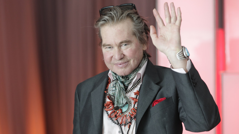 Val Kilmer with sunglasses on head waving at a United Nations event in 2019