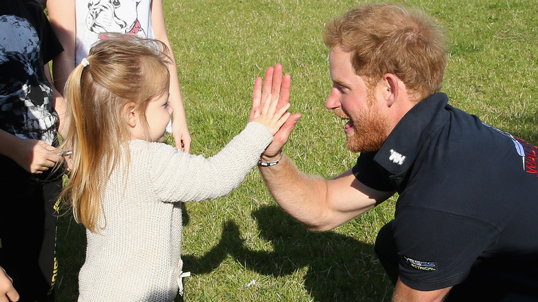 Prince Harry high-fives a young girl as he walks the route to Ludlow with Walking with the Wounded's Walk of Britain team on September 30, 2015 in Ludlow, England.