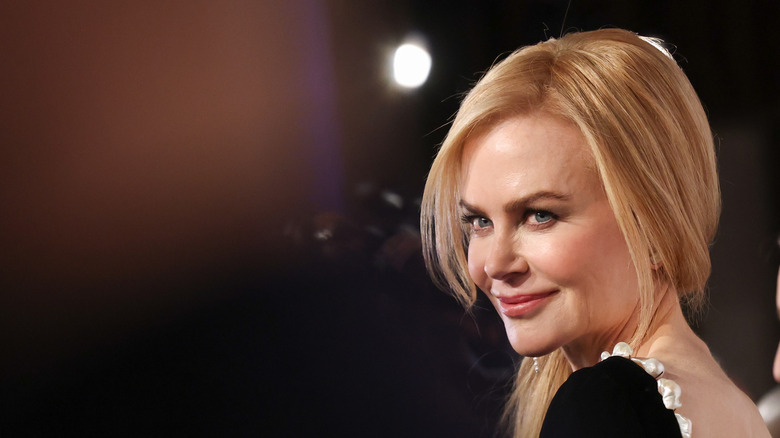 Nicole Kidman looking over her shoulder in a black dress