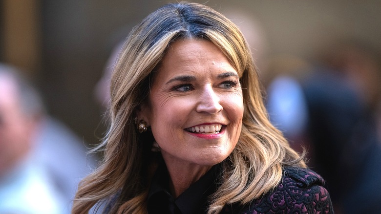 A smiling Savannah Guthrie looking over her shoulder