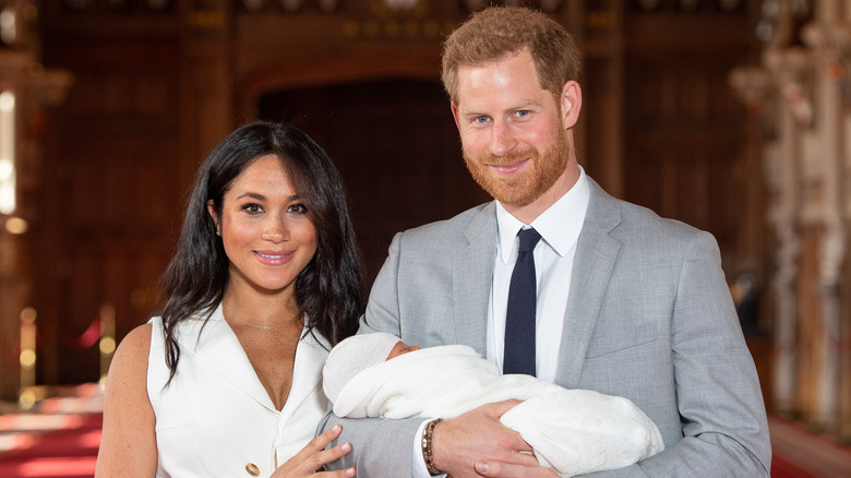 Prince Harry and Meghan Markle holding their son