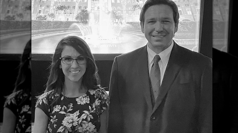 Black and white photo of Lauren Boebert in a floral dress and Ron DeSantis in a suit smiling
