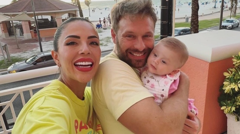 Jasmine Pineda smiling in a selfie with her family by the beach.