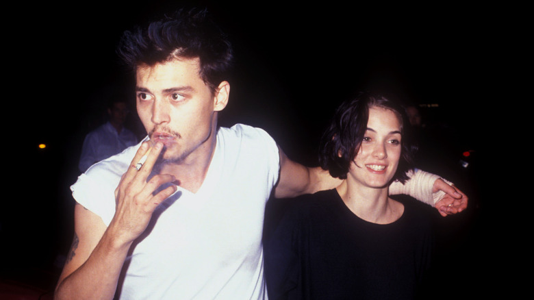 Johnny Depp smoking with one arm around Winona Ryder.