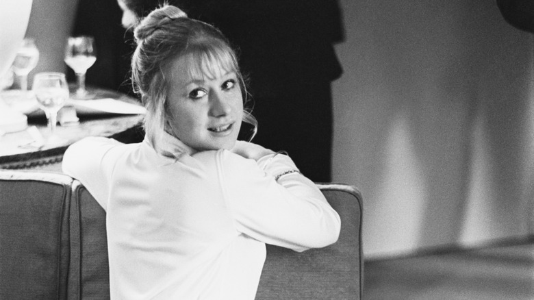 A young Helen Mirren posing on a sofa