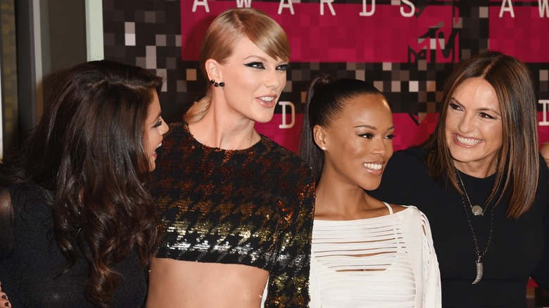 Selena Gomez, Taylor Swift, Serayah, and Mariska Hargitay laughing on the VMAs red carpet.